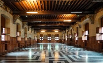 Przestronna sala w zabytkowym zamku z ozdobną stolarką i posadzką